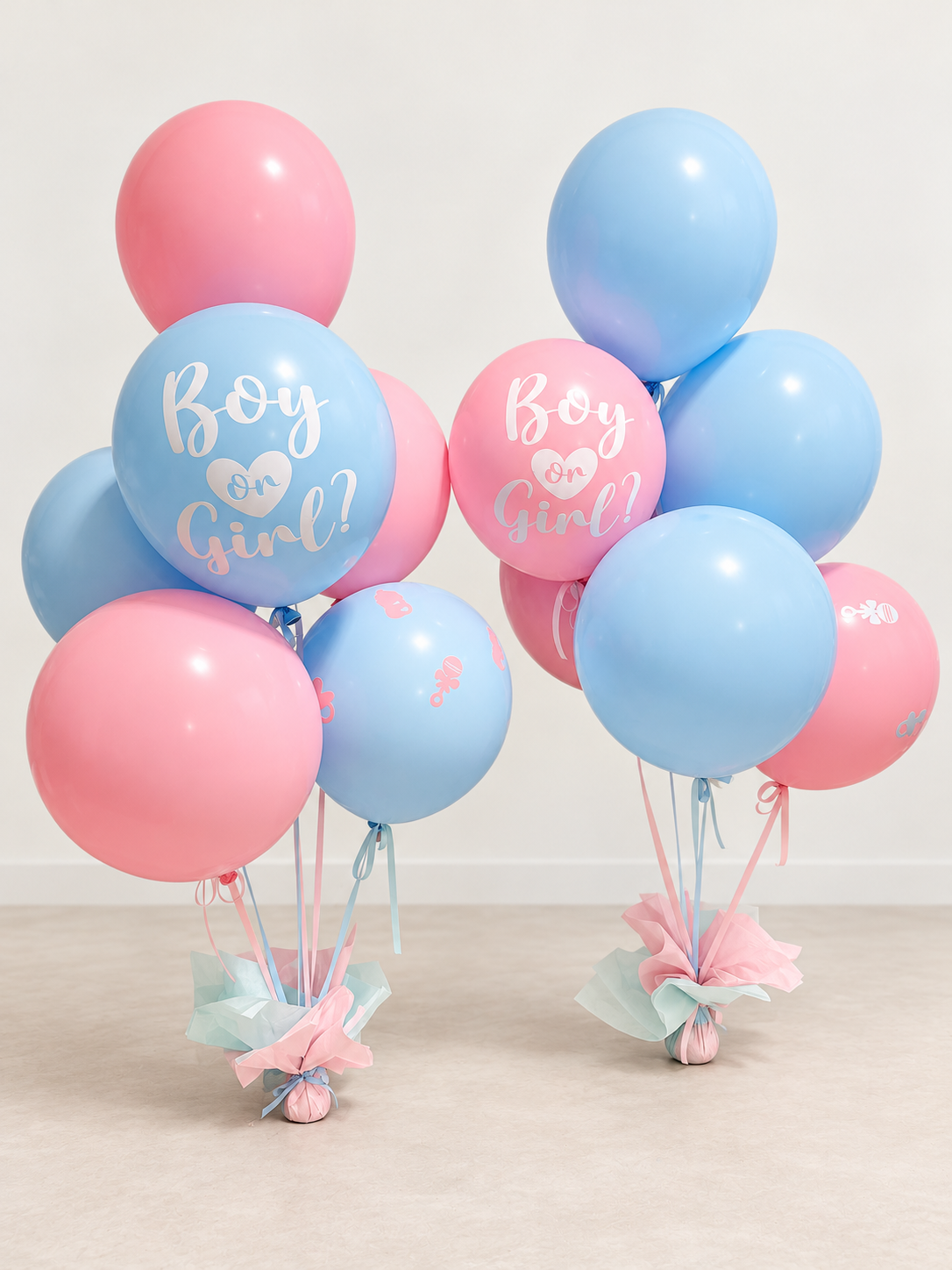 Two pink and blue Boy or Girl gender reveal Signature balloon bouquets with custom vinyl and coordinated weights